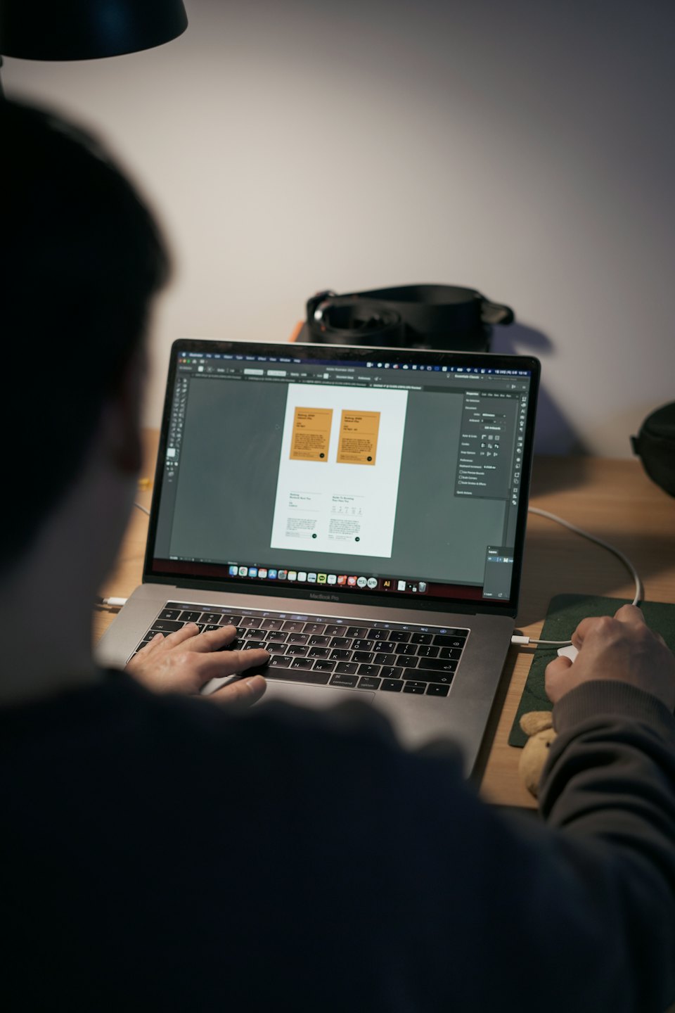 Projektant pracujący w Adobe Illustrator na MacBooku Pro.